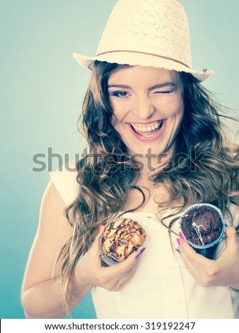 Bakery, sweet food and people concept. Closeup crazy summer woman curly hair straw hat holding cakes cupcakes on breast