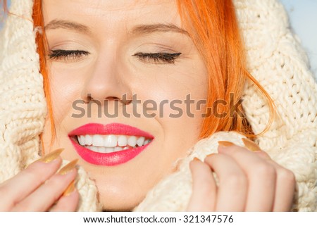 Winter fashion. Close up beauty face portrait red hair young woman in warm clothing white hood on head outdoor enjoying sunlight on sunny day.