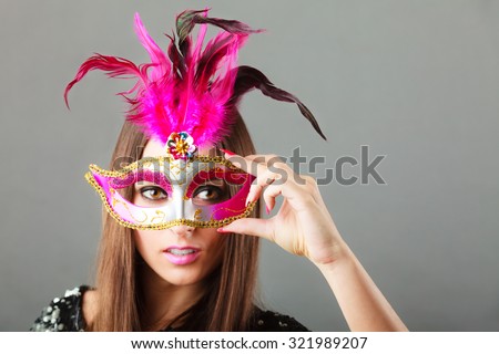 Holidays, people and celebration concept. Closeup woman face with carnival venetian mask on gray background.