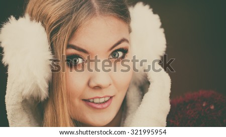 Portrait of pretty attractive fashionable woman in fall forest park. Gorgeous young girl in white fur earmuffs. Autumn winter fashion.