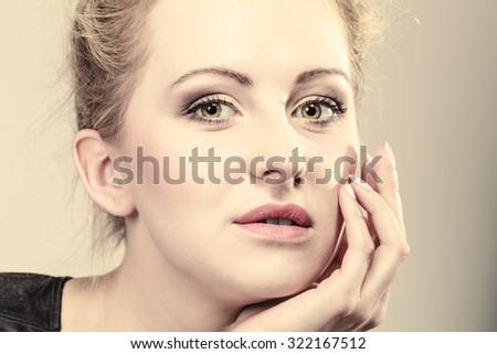 Portrait of young beautiful pensive girl blonde woman face gray background