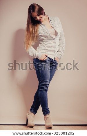 Fashion. Young long hair fashionable woman jeans pants shirt. Female model posing in full body filtered photo