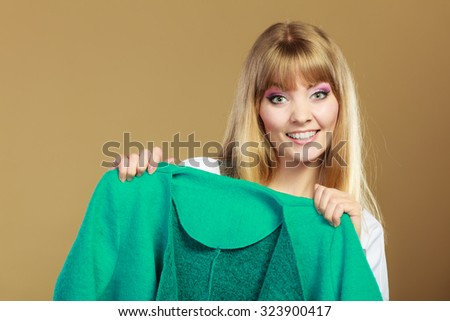 Retail and sale. Blonde girl fashionable woman buying clothes. Client customer showing green coat