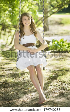 Red Haired High School Girl Swings Barefoot in Sunlight