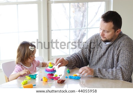 Little girl and father creating toys from play dough