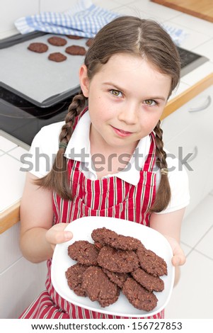 Cute little girl showing off the cookies she just made.