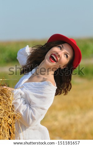 Happy young women in the field of haystack in sunny day