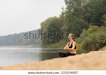 young woman practicing yoga at the forest lake, nature concept, health care concept