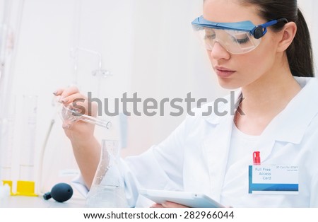 chemical laboratory scene: attractive young student scientist observing liquid measures, medicine concept
