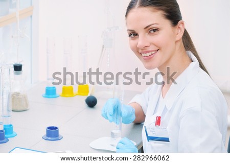 chemical laboratory scene: attractive young student scientist observing liquid measures, medicine concept