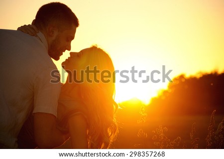 stunning sensual young couple in love posing in summer field at the sunset, happy lifestyle concept