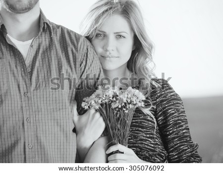 black and white portrait of sensual young couple in love posing in summer field, happy lifestyle concept