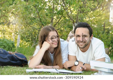 couple of young students studying in the park by the campus, lifestyle concept