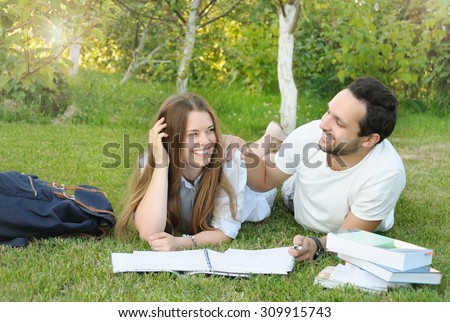 couple of young students studying in the park by the campus, lifestyle concept