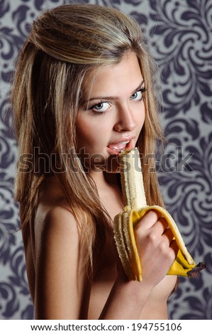 sexy woman holding a half-peeled banana in her hand