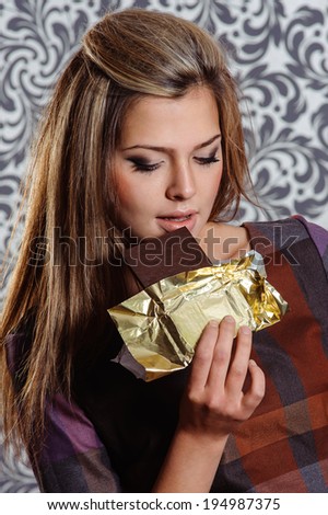 Beautiful portrait of a cute brunette girl in act to eat a chocolate