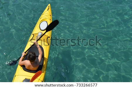 Kayaker paddling in yellow boat on clear water Stok fotoğraf © 