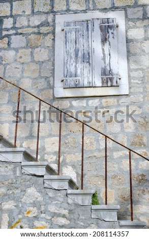 window with stone stairs in old stone house, Croatia