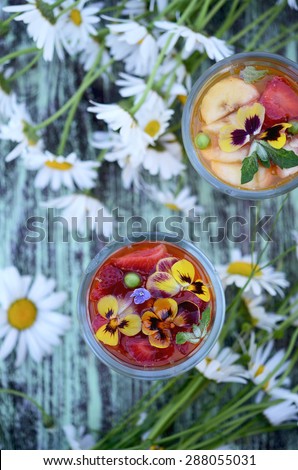 Jelly dessert with strawberries and flowers in glass