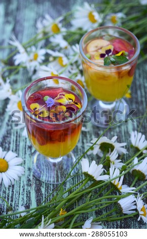 Jelly dessert with strawberries and flowers in glass