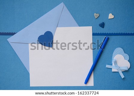 Blue envelope and white blank paper with hand made heart crafts