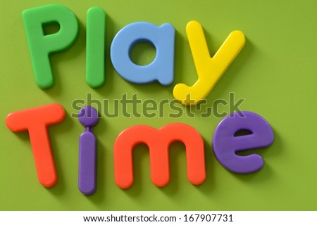Close up of Play Time words in colorful plastic letters on green background
