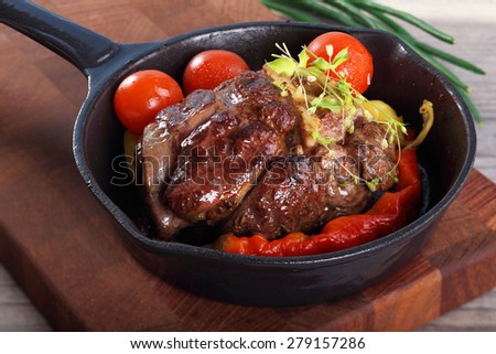roast beef in a frying pan with vegetables