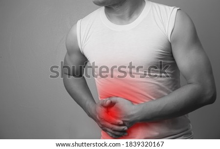 Blurry and out of focus a man suffering from stomach ache ,appendix pain, an inflammation of the appendix over gray background. Black and white with a red accent,Medical healthcare concept. Stok fotoğraf © 