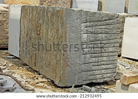 Huge Indian granite block stacked in a stone processing factory for cutting and polishing into flooring slabs used in building construction.