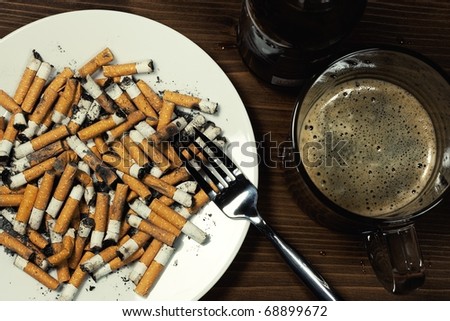 Plate with cigarettes stubs with fork and beer