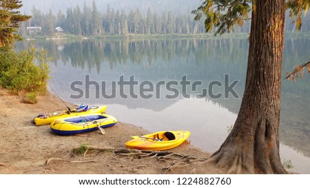 yellow kyaks and a raft on the bank of lake Jameson, reflecting the mountains and trees on the lake, sunrise early fall 2018 Stok fotoğraf © 