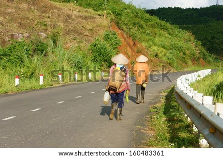 DAK LAK, VIET NAM- SEPTEMBER 4: People walking on countryside road to coming home after finish work in Viet Nam country side on September 4, 2012