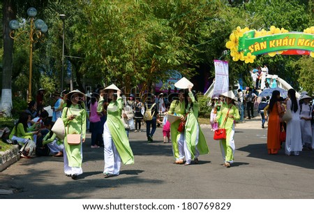 HO CHI MINH, VIETNAM- MARCH 8: Group of young girl in Vietnamese traditional dress - conical hat, ao dai- walking in park on Aodai festival, they so charming, sweet, beautiful, Viet Nam, March 8, 2014