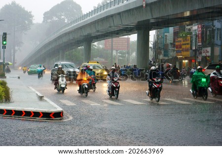 HO CHI MINH CITY, VIETNAM- SEPT 5: Traffic of Asia city in raining season, crowd of people wear raincoat, moving by motorbike in hurry on heavy rain, raindrop spatter, Saigon, Viet Nam, Sept 5, 2014