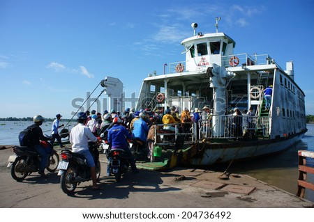 MEKONG DELTA, VIETNAM- JULY 7: Crowd of people wear hetmet sitting on motorbike to cross the river by ferry boat, this is  passenger transport vehicle on water at My Loi ferry, Viet Nam, July 7, 2014