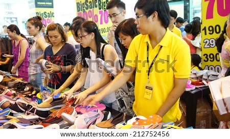 HO CHI MINH, VIETNAM- AUG 23: Crowded, busy atmosphere at Tax shoping centre, group of Asia people buy modern clothing  in sale off season, colorful store inside Tax center,  Vietnam, Aug 23, 2014