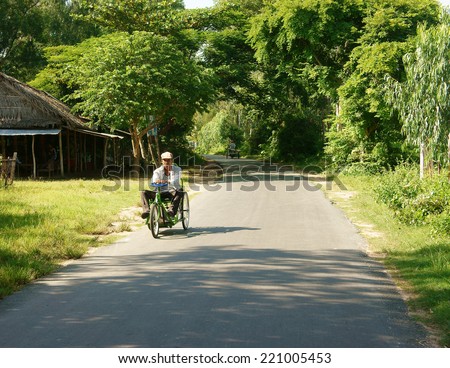CHAU DOC, VIET NAM- SEP 9: Vietnamese people on wheelchair moving on country road, disability man confident and earning living by lottery ticket vendor, is popular business, Vietnam, Sept 20, 2014