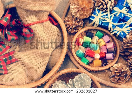 Amazing, colorful Xmas gift and pine cone in basket, decoration material for christmas season, present bag from burlap, beautiful knot, vintage style