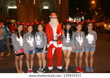 HO CHI MINH CITY, VIET NAM- DEC 24: Group of teen girl standing outside to take photo with Santa Claus in Christmas night, pretty girl happy with friend, smiling, Sai Gon, Vietnam, Dec 24, 2014
