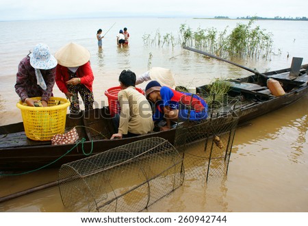 DONG NAI- VIET NAM- AUST 31: Group of Asian fisherman fishing on Tri An lake, a branch of Dong Nai river, crowd of people collect river fish on row boat, Vietnam, Aust 31, 2014