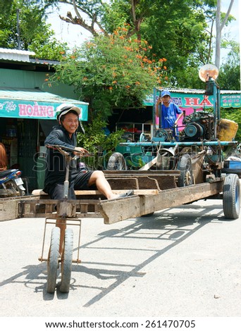DONG THAP, VIET NAM- JULY 25: Asian man control motorized vehicle moving on route, he long, unsafe vehicle renovate as home made, this circulate on street make danger for people, Vietnam, Feb 25, 2014