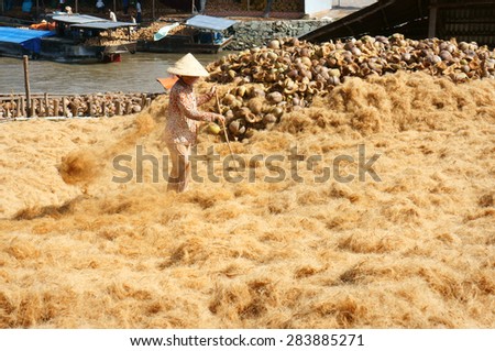 BEN TRE, VIET NAM- JUNE 1: Group of Asian worker work hard at coconut fiber trade village, Vietnamese woman working in dust, this is material area from coir of Mekong Delta, Vietnam, June 1, 2015