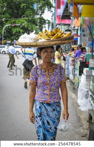 The street at Yangon, MYANMAR, July 2: woman selling fruit with thanaka on her face, July 2, 2014 inYangoon, Myanmar. Thanaka is a yellowish-white cosmetic paste made from ground bark