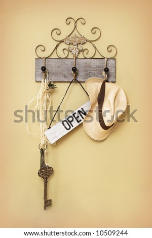 Open Sign hanging next to a key and hat