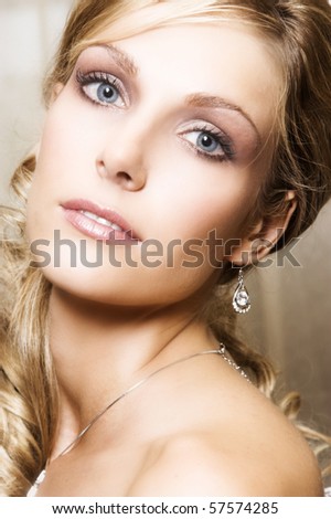 Beautiful Blond bride with blue eyes wearing diamond jewelery