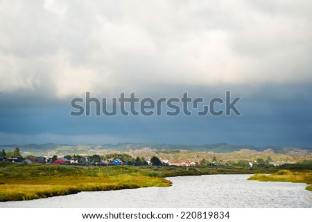 Cloudy landscape of norwagian village near the river