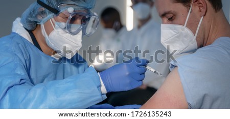 hand of medical staff injecting coronavirus covid-19 vaccine in vaccine syringe to arm muscle of caucasian man for coronavirus covid-19 immunization, coronavirus covid-19 vaccination, selective focus