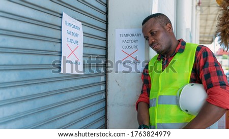 african american factory engineer at factory gate with annoucement of factory closed due to coronavirus covid-19 pandemic caused unemployment economics crisis and recession ストックフォト © 