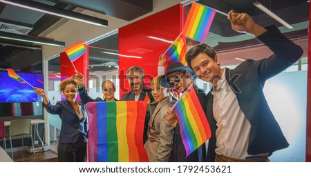 diverse group of LGBTQI business people in business office with rainbow flag on hand form up team for LGBTQ campaign movement 商業照片 © 