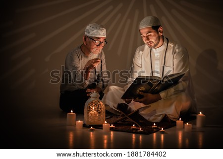 two muslim people read and study islam holy al quran book together during ramadan period. Al quran book with written arabic calligraphy meaning of Al Quran Stok fotoğraf © 
